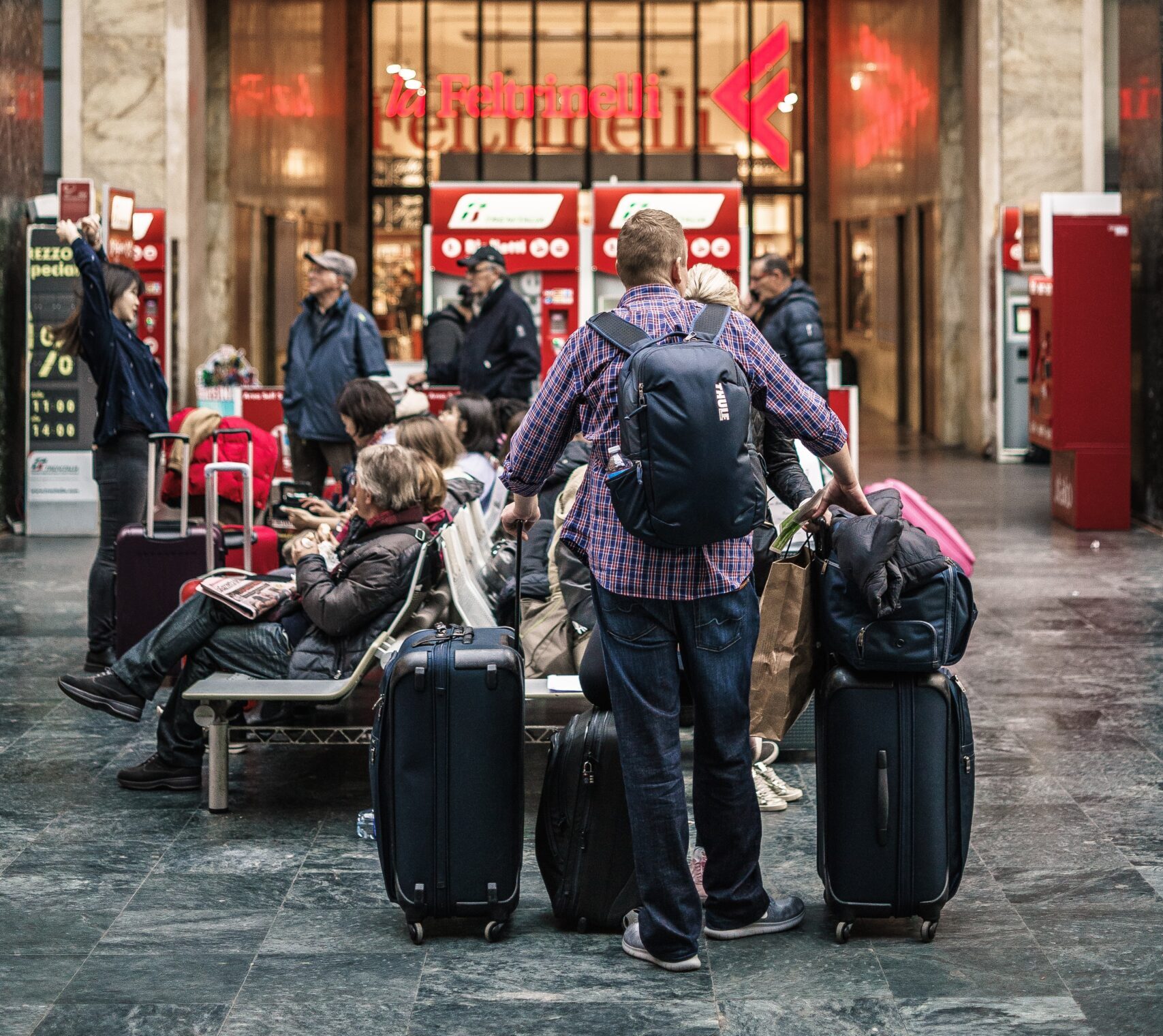 Over packing: Man with lots of suitcases. Photo by Tommaso Pecchioli on Unsplash