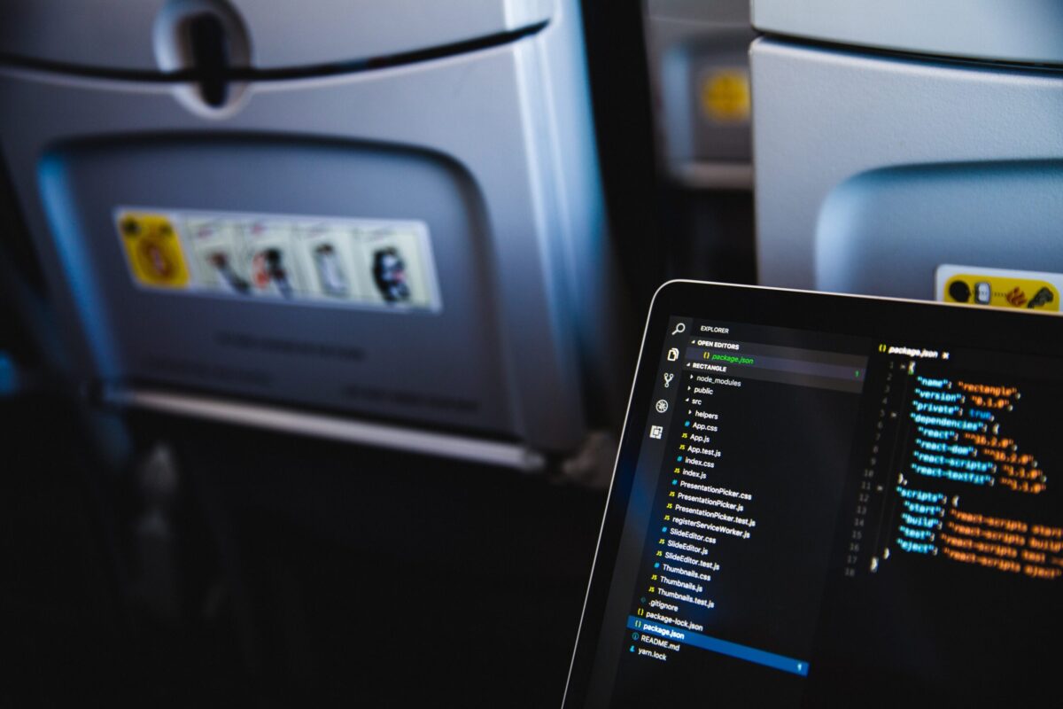 How to Make Money While Traveling: Computer on an airplane: Photo by Marten Bjork on Unsplash